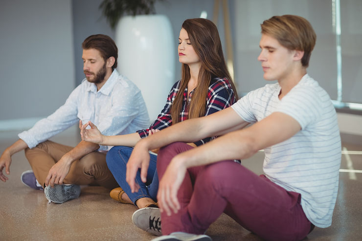 trois salariés faisant du yoga pour le bien-être en entreprise