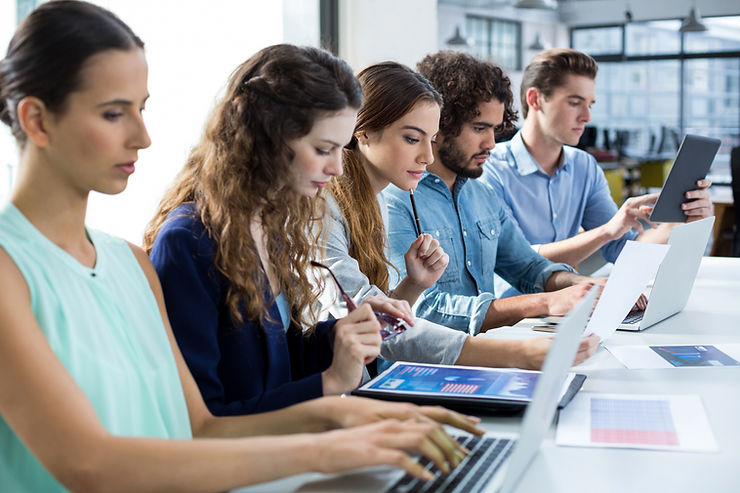 Une réunion de formation interne animée par un jeune expert digital. Image évoquant les nouvelles approches comme le reverse mentoring pour développer les compétences numériques en entreprise.